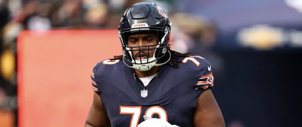 A football player in a dark Chicago Bears uniform and helmet stands on the field, wearing number 70.