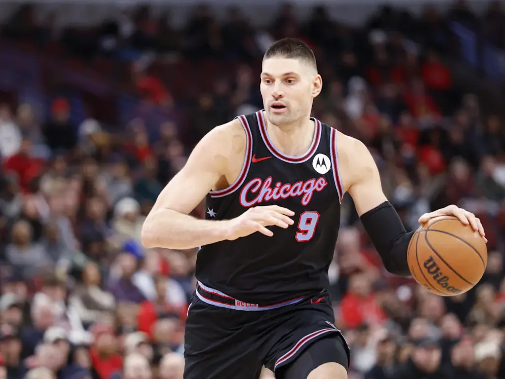 A Chicago Bulls basketball player wearing a black jersey with number 9 dribbles a basketball on the court during a game.